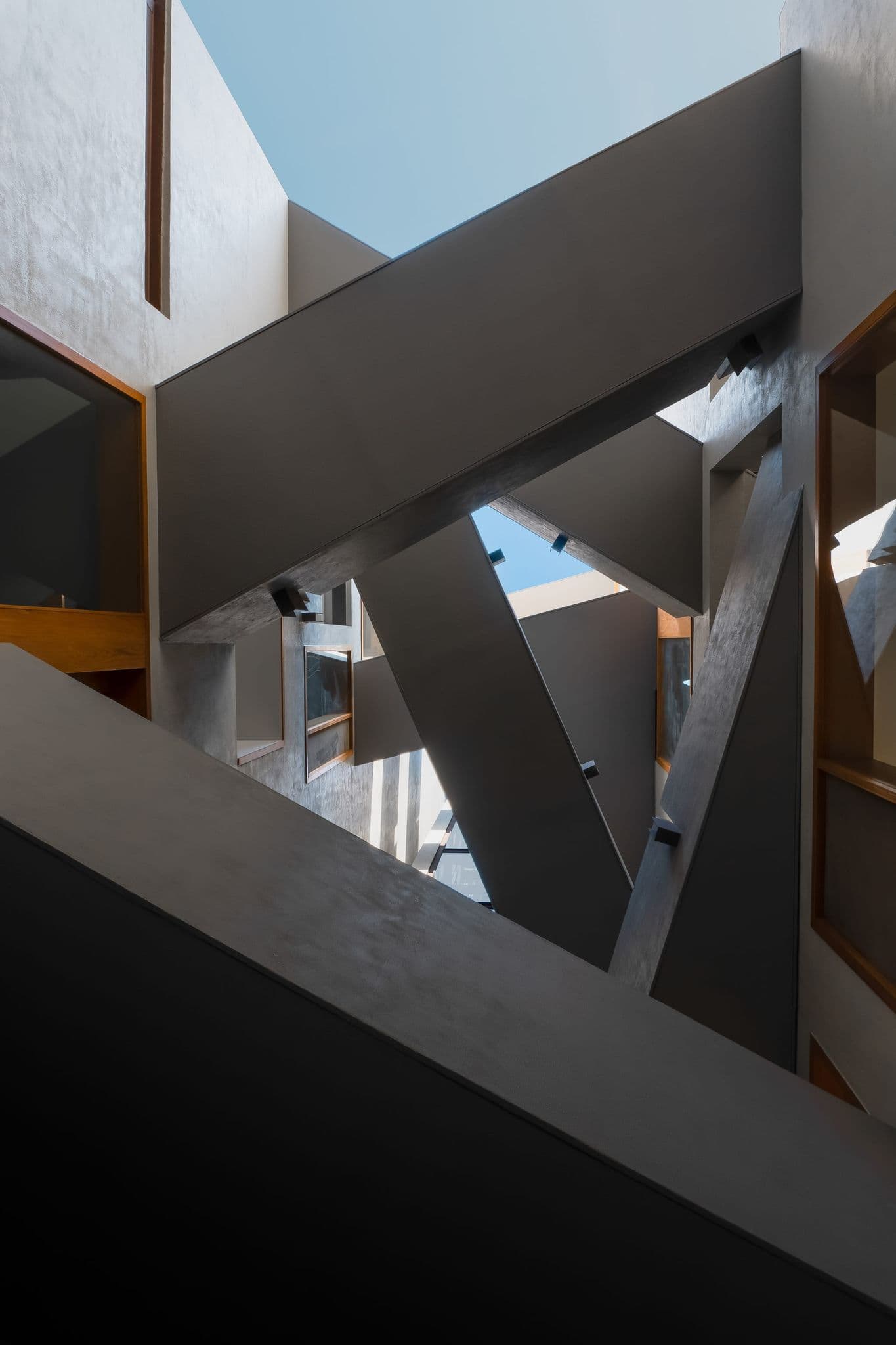 Hira facade — material tension between stone, concrete, and steel