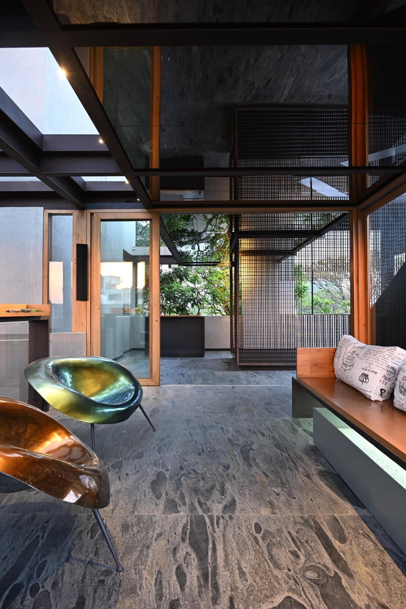 Stone wall passage with suspended brass detail and greenery — daylight