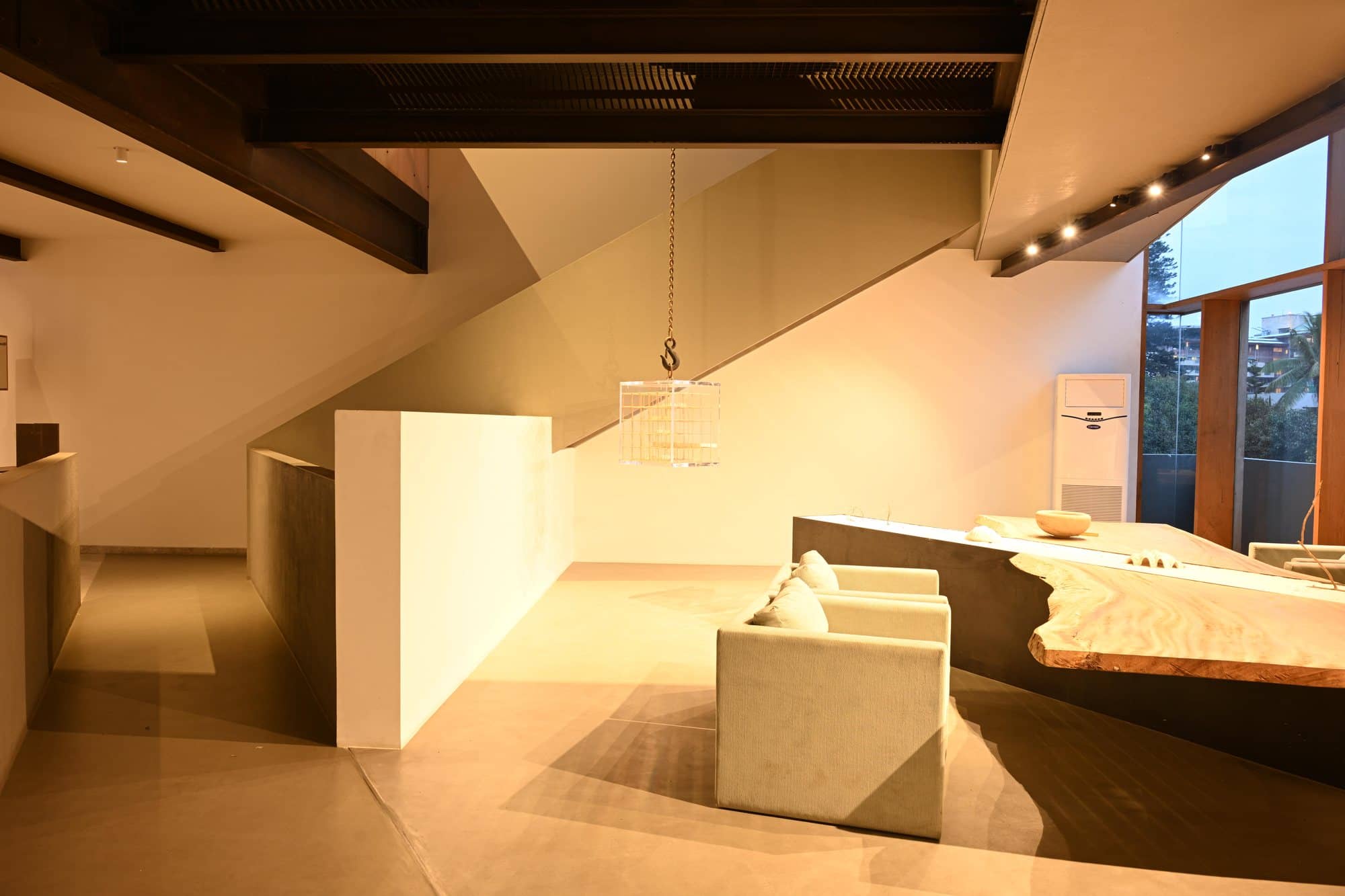 Sculptural wood worktable beneath the sloped roof — daylight